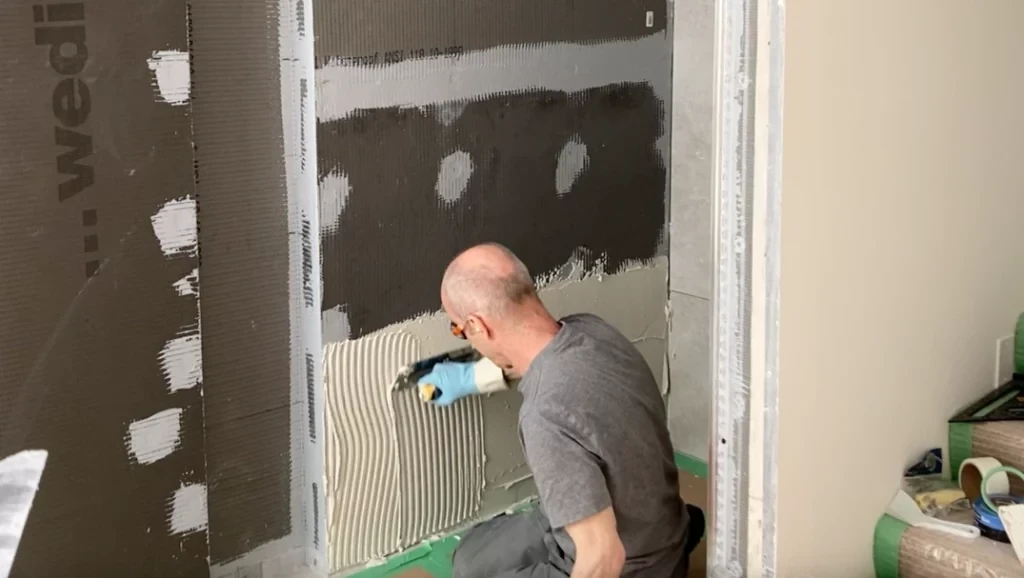 notching wet thinset with trowel -Lay shower tile post