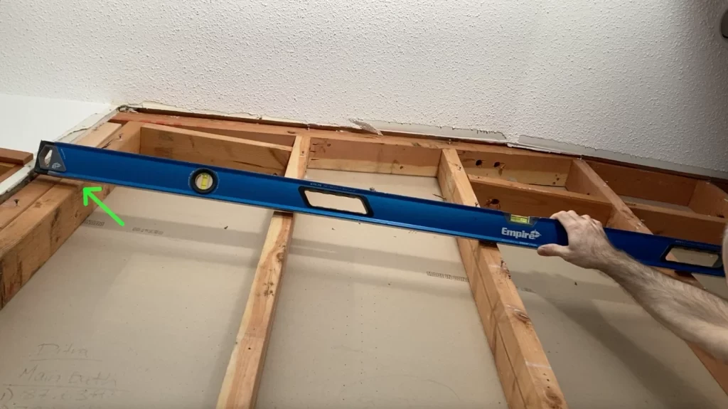 Using spirit level to check flatness of stud plane- Lay shower tile post