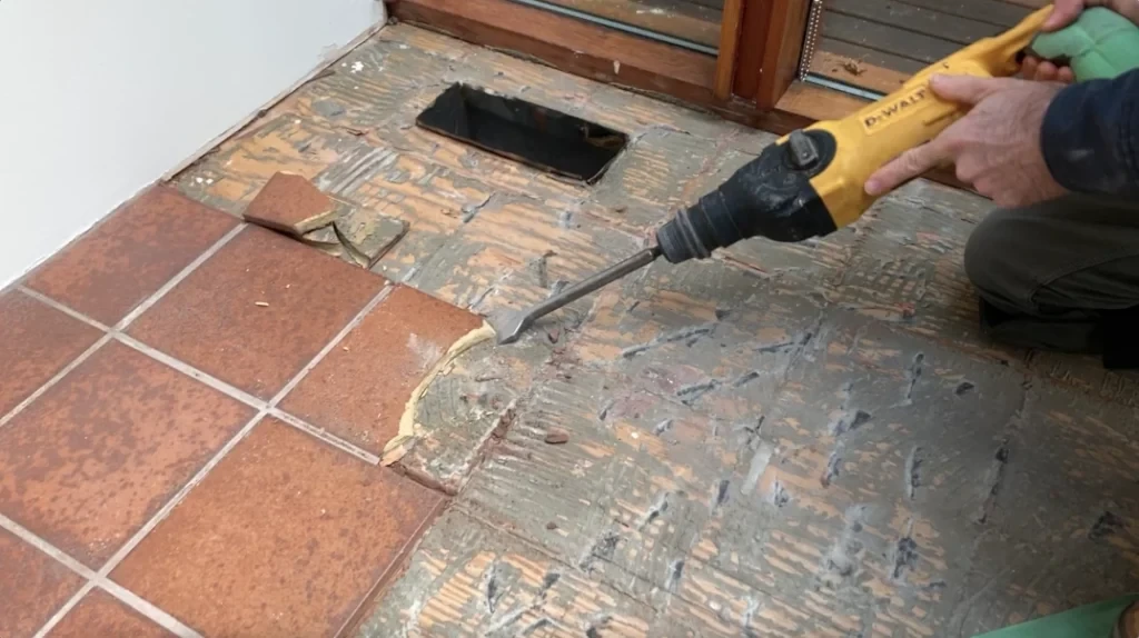 Chiseling tile off the floor with Hammer Chisel - removing tile from a bathroom wall post