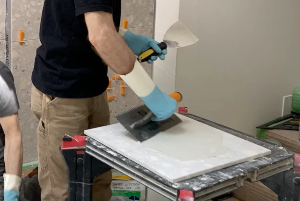 Back buttering wall tile -Lay shower tile post