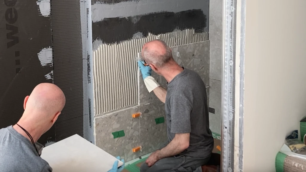 Placing leveling clips on shower wall tile